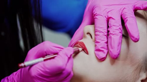 Makeup Artist Applying Lip Liner to Young Woman