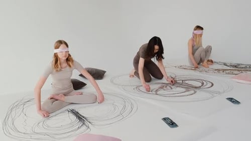 Young People Drawing Blindfolded in Bright Room