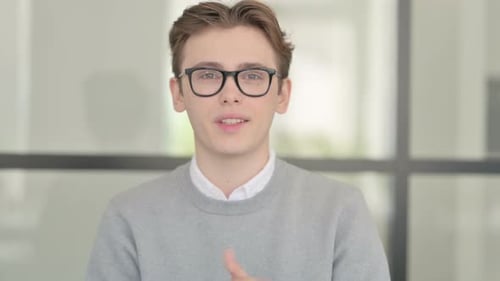 Friendly Young Adult Talking to Camera in Office