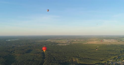Aerial View of Hot Air Balloons Over Green Landscape
