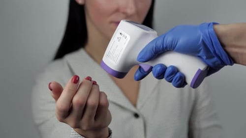 Temperature Check with Non-Contact Thermometer on Hand