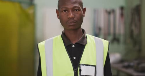 African American male factory worker at a factory wearing a high vis vest