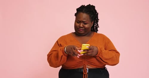 Surprised Plump Black Lady Looks Into Phone Clicks on Gadget