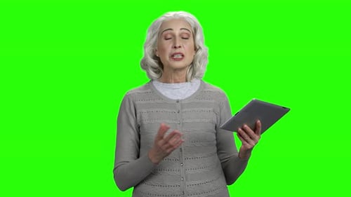 Senior Woman Talking With Tablet on Green Screen