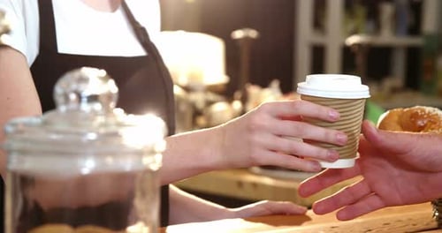 Barista Serving Coffee To Go To Customer