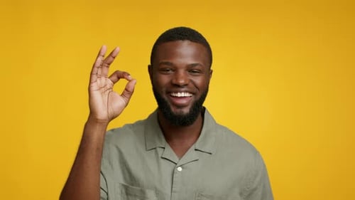 Happy Young Adult Makes Okay Gesture
