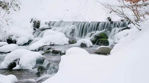 Wonderful Frozen Foot of a Waterfall with a Powerful Stream of Water at Winter Carpathian Mountains