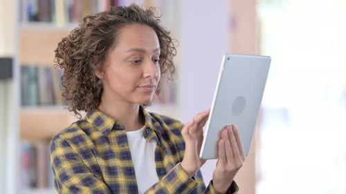 Woman with Curly Hair Using Tablet Looking Sad