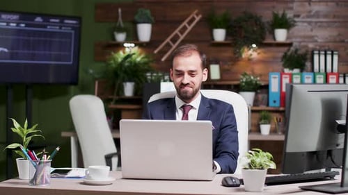 Porträt eines jungen gutaussehenden Geschäftsmannes, der am Laptop