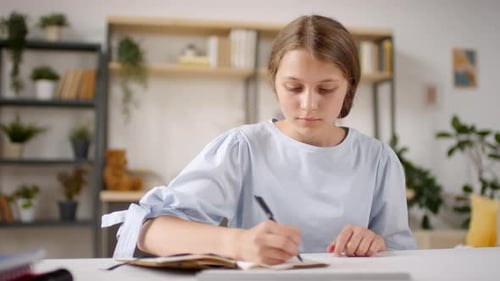 Adolescente parlant par appel vidéo tout en apprenant à distance