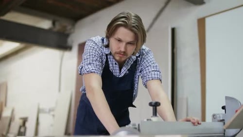 The Craftsman Is Working on Electric Saw Machine in a Furniture Factory