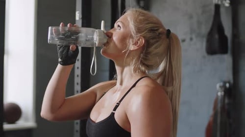 Woman Drinking Water after Gym Workout