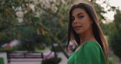 Beautiful Woman in Green Dress Turning Face Looking at Camera