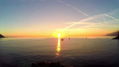 Tranquil Ocean at Sunrise or Sunset with Sailboats