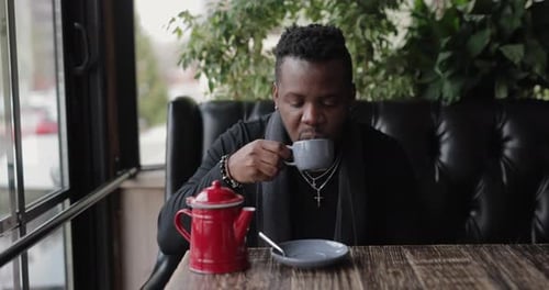 African American Man Drinking Tea Sitting in a Cafe, Slow Motion
