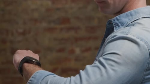 Man Using Smartwatch, Swiping Finger on Screen