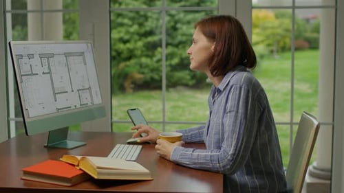Woman Working at Desk With Computer and Phone