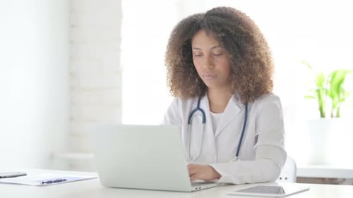 Afrikanischer Arzt beim Kopfschütteln als kein Zeichen bei der Verwendung des Laptops in der Klinik