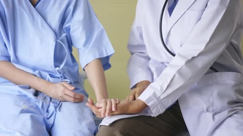 Doctor Comforting Patient By Holding Their Hands