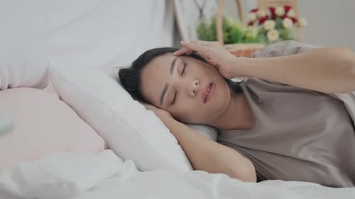 Woman Lying in Bed With a Headache