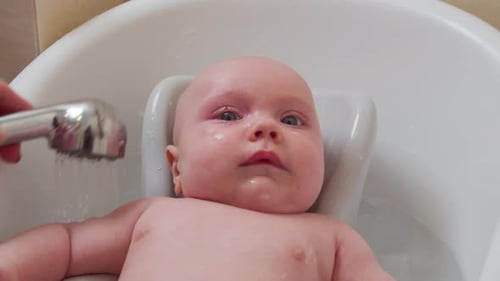 Baby Gets a Bath in White Tub