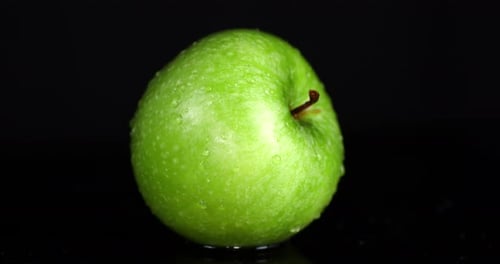 Rotierende frische grüne Äpfel mit Wassertropfen.
