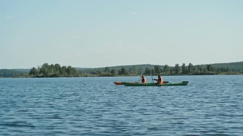 Young Adults Kayaking on a Calm Lake