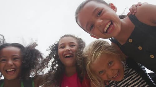 Happy Girls Embrace Laughing Together at the Camera