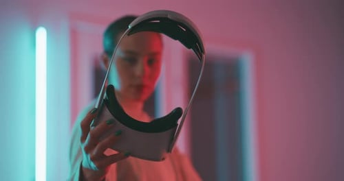 Close up of young woman looking into the lens through metaverse goggles
