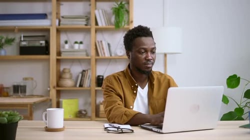 Man Working on Laptop at Desk Indoors