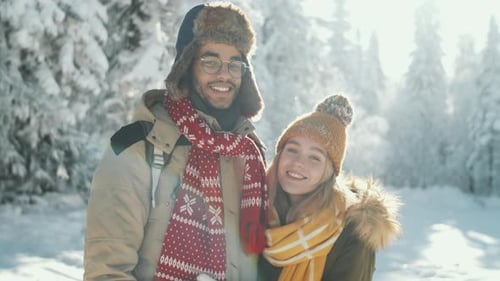 Portrait of Cheerful Young Couple in Snowy Forest