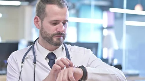 Portrait of Focused Young Doctor Using Smart Watch