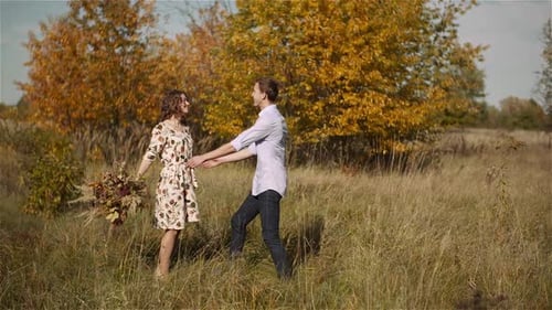 Young Couple Walking on a Meadow