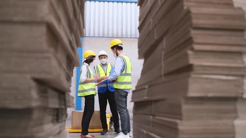 Warehouse or factory workers with hygiene mask man and woman meet and discuss together