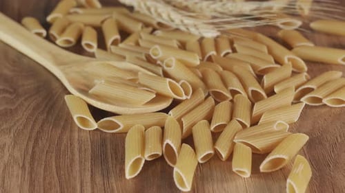 Close Up of Penne Pasta with Wooden Spoon