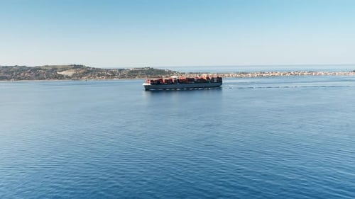 Big Container Ship Sails in the Calm Sea in the Distance