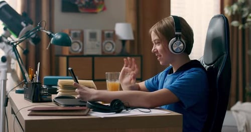 Teen Video Chatting on Phone with Headphones