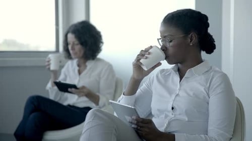 Women Work on Tablets in Waiting Area