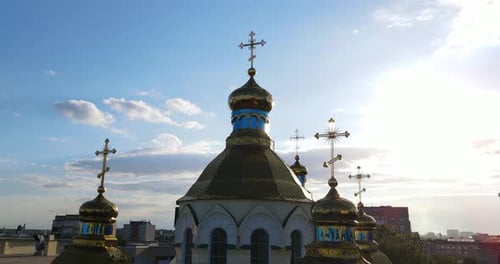 La cúpula dorada de la iglesia con una cruz ortodoxa se eleva sobre la ciudad