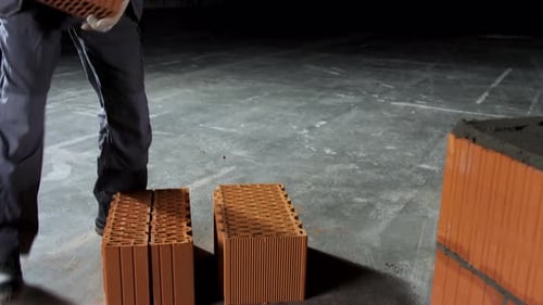 Industrial bricklayer worker placing bricks