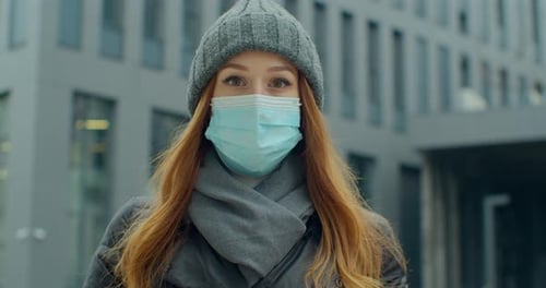 Close Up Portrait of a Beautiful Redhead Young Woman in a Hat Wearing Protective Medical Face Mask