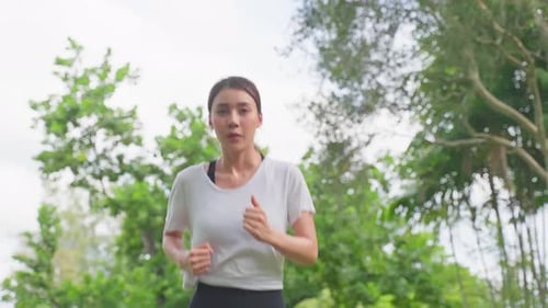 Asian young beautiful sport woman running on street in public park.