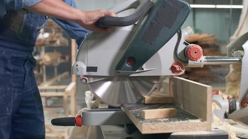 Carpenter Uses Power Saw in Woodworking Shop