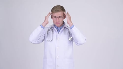 Stressed Young Doctor Massages Temples