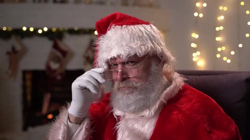 Man in Santa Costume Adjusts Glasses
