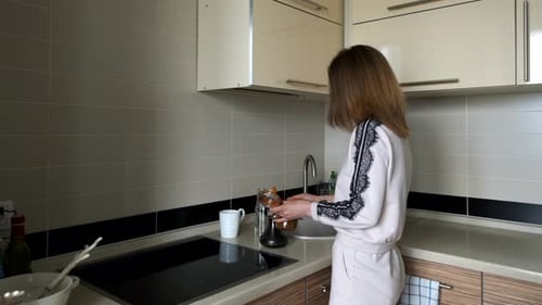 Woman Prepares Coffee in Modern Home Kitchen