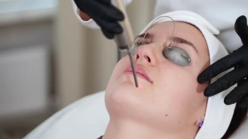 Woman Receives Laser Treatment on Face in Clinic