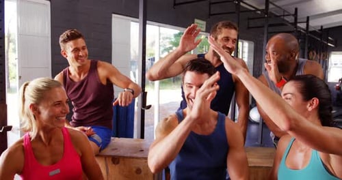 Athletic Group High Fiving After Gym Workout