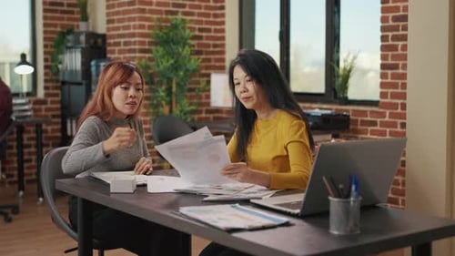 Two Women Reviewing Data in Modern Office