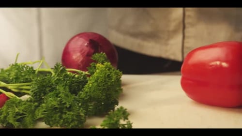 Chef Slices Fresh Red Pepper Among Vegetables